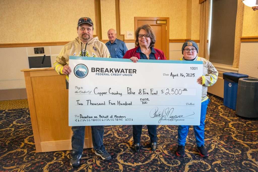 Copper Country Police and Fire Relief Fund volunteers accept big check donation for $2,500.