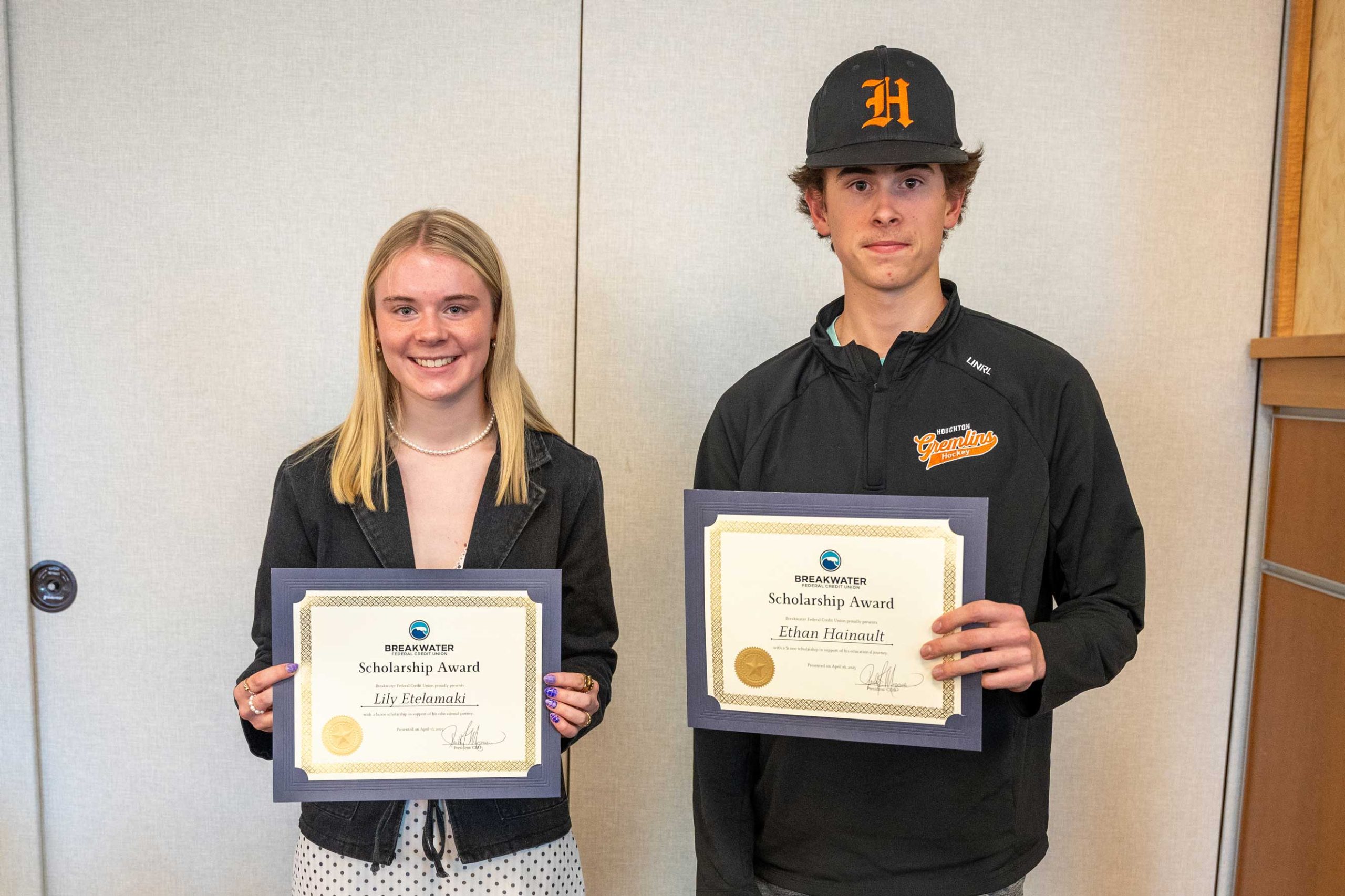 Lily Etelamaki and Ethan Hainault smile with their scholarship awards.