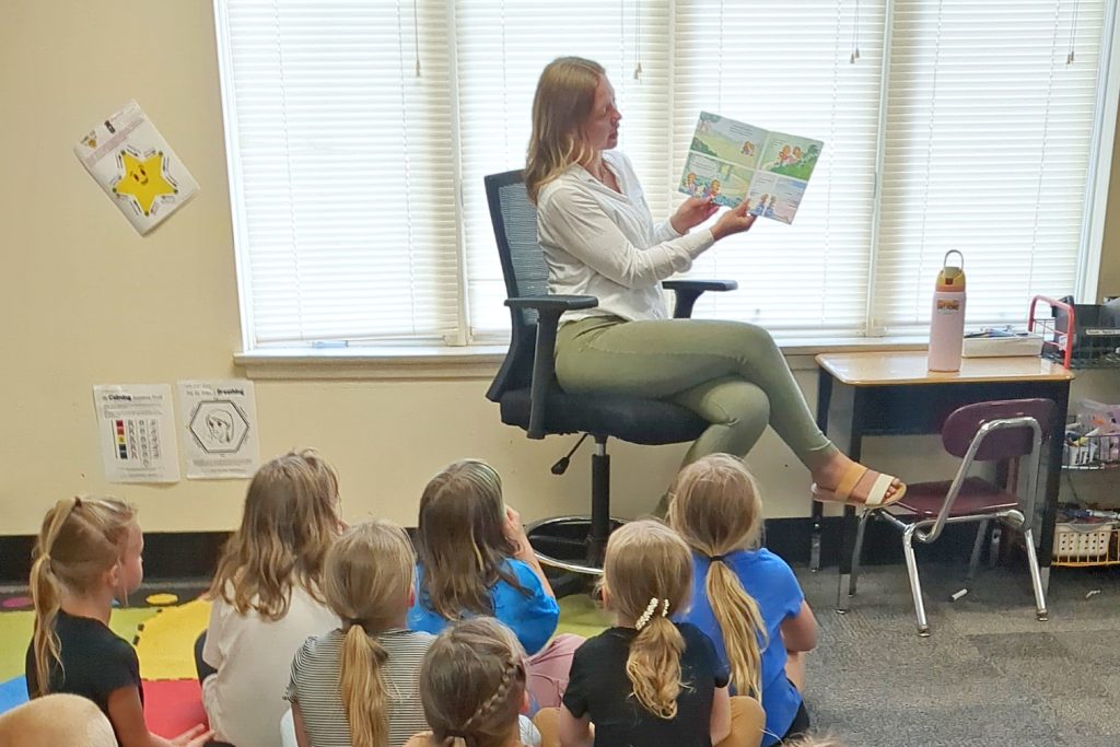 Breakwater employee reads a story to a 2nd grade students.
