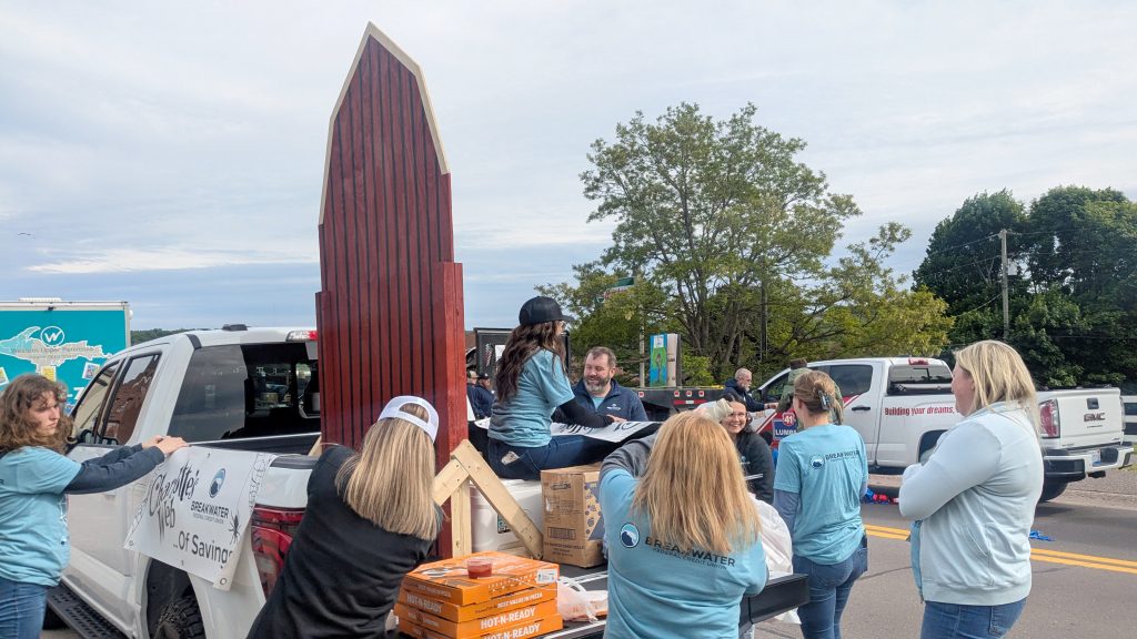 Breakwater staff gather around truck to decorate for parade.