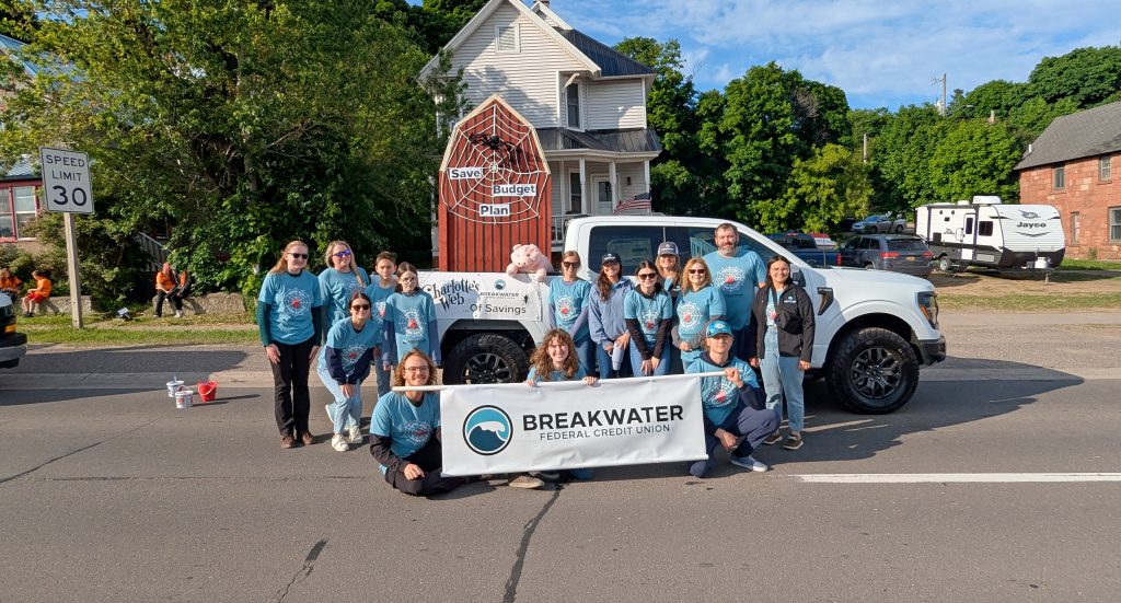 Breakwater parade walkers pose for photo with the decorated truck and a Breakwater banner.