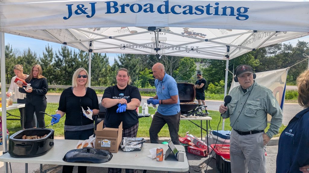 Breakwater employees, Shannon & Nicole, smile for photo while serving brats and dogs at member cookout.