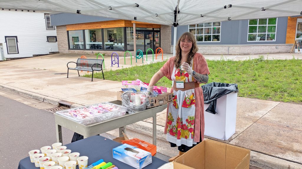Keweenaw Co+op staff fills cups with grapes to giveaway at Key Ingredients.
