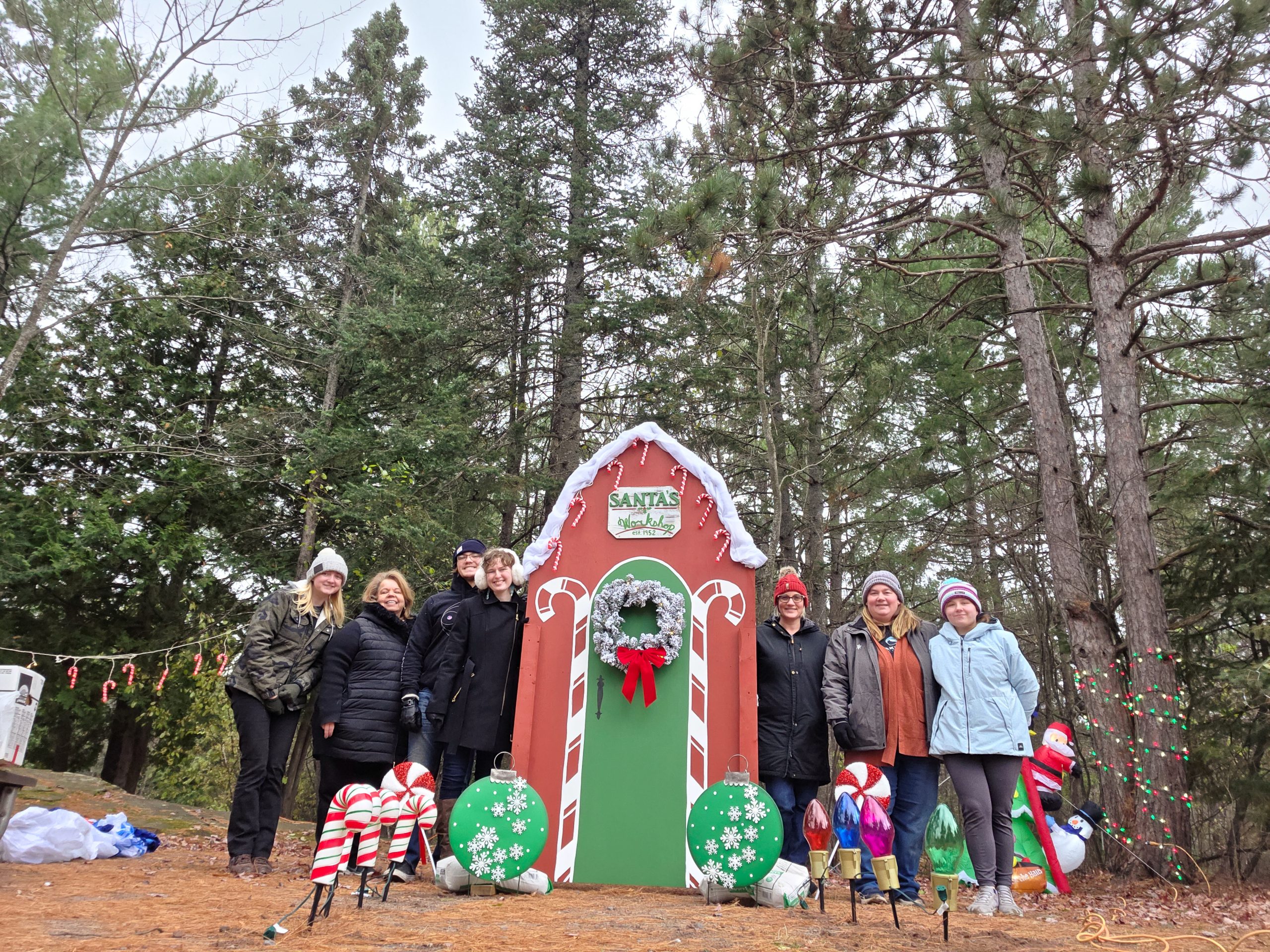 Breakwater employees pose for photo next to Santas Workshop designed for Hancock Lights the Night event.