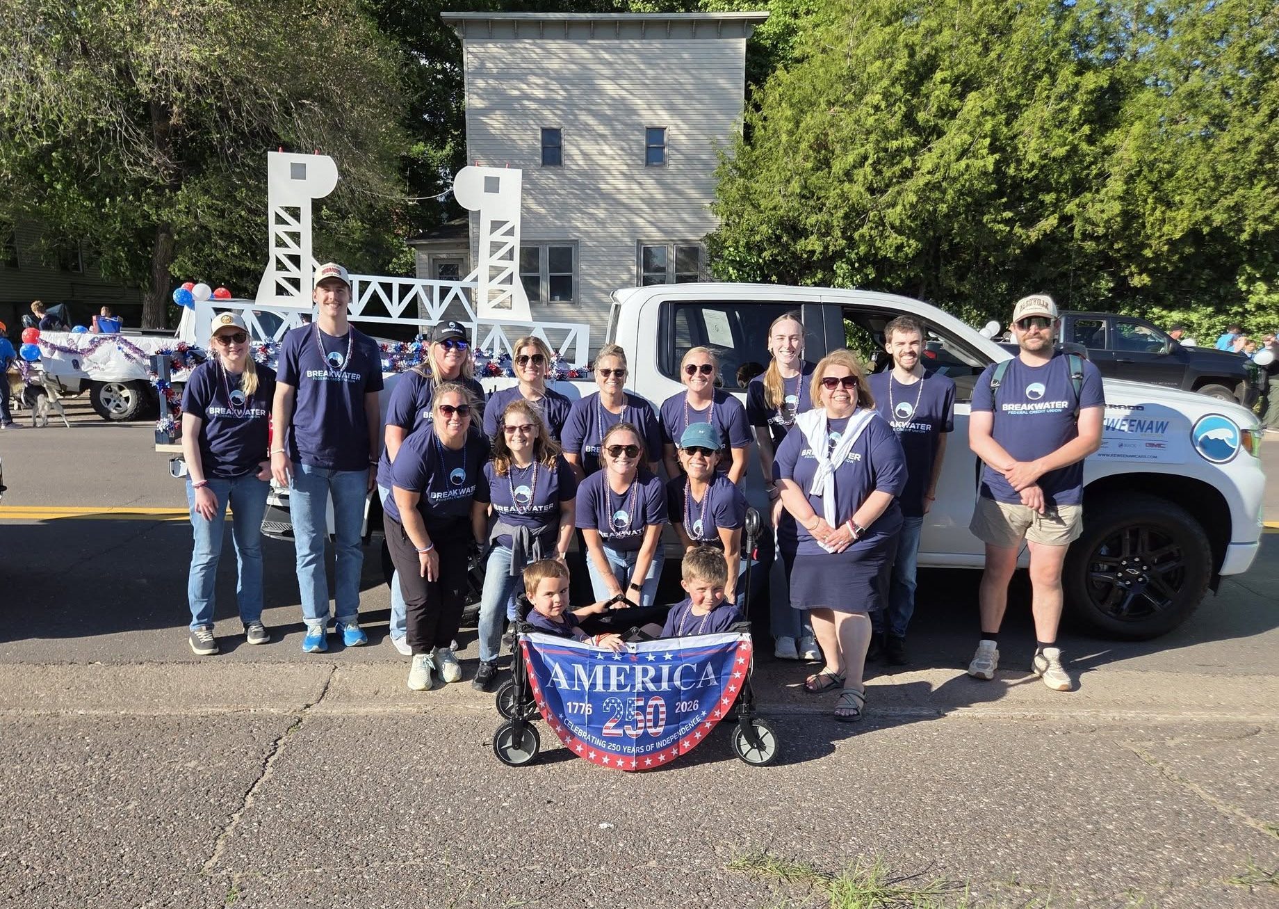Breakwater employees and friends and family pose for a picture with their Bridgefest float.